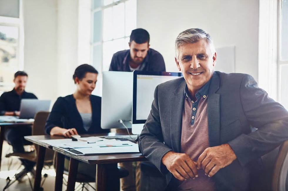Portrait of mature businessman with his colleagues in the background