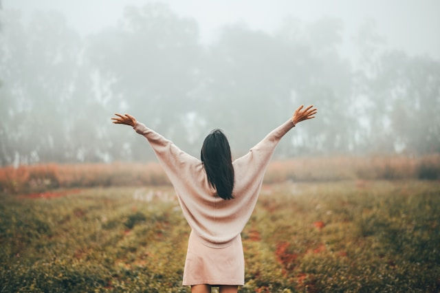 rear view of woman with open arms relaxing