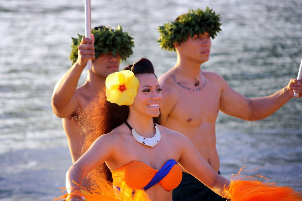 two men and a woman in Hawaiian costume dancing