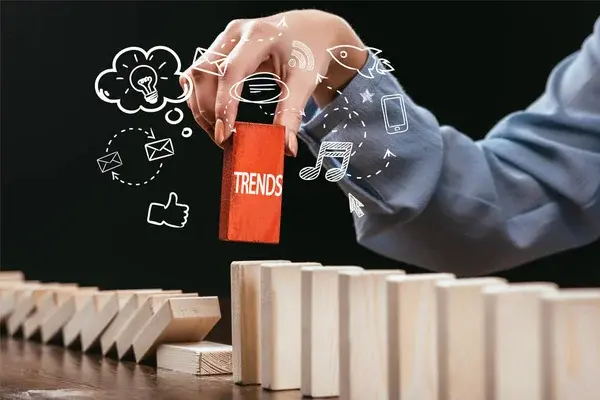 woman picking red block with word 'trends' out of wooden bricks,