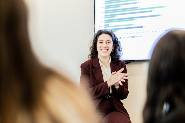 a woman in a business suit talking to a group of people