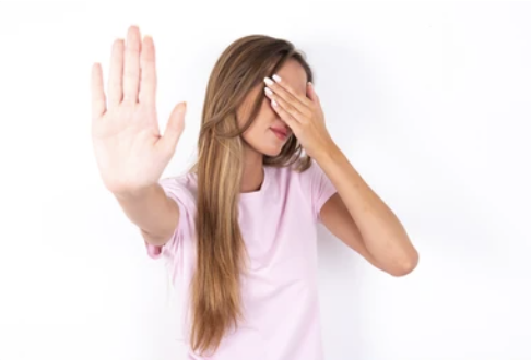 A woman covering her face with her hand.