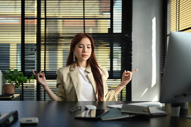 woman in a meditation position at her desk