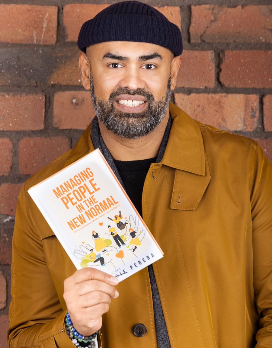 A photo of Richie Perera holding a book.