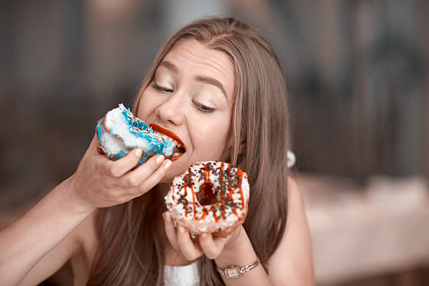 A girl eating two donuts at the same time