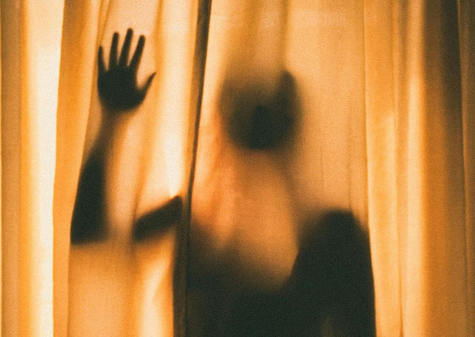 Silhouette of a person with raised hand, visible through backlit beige curtains, creating a mysterious and dramatic atmosphere.