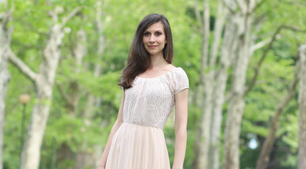 A woman wearing a white dress in the middle of the woods.