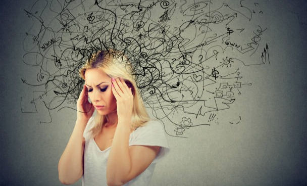 Woman with a mess in her head with gray background.