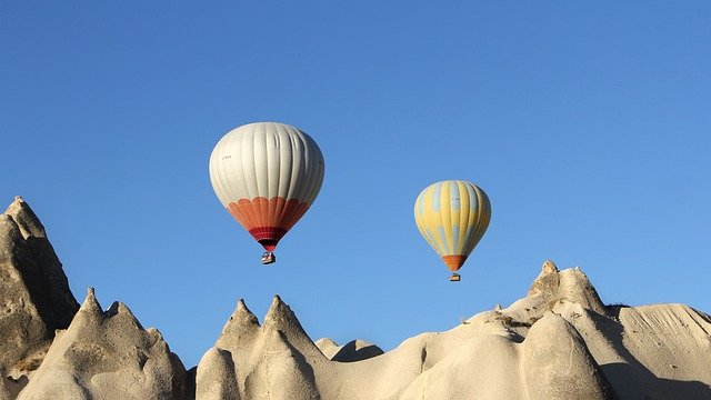 Two parachutes flying over the mountains.