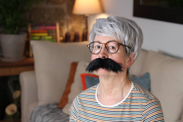 A old lady in a room with a mustache disguising her self.