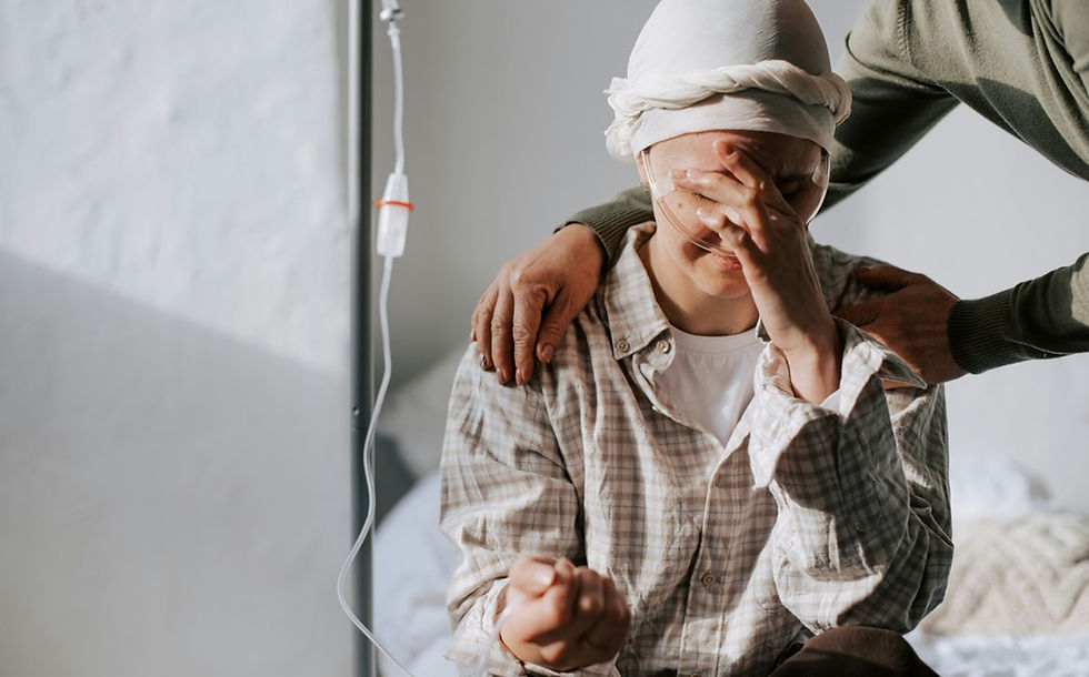 Young patient with a bandaged head cries in a hospital bed as an adult comforts them, with an IV nearby.
