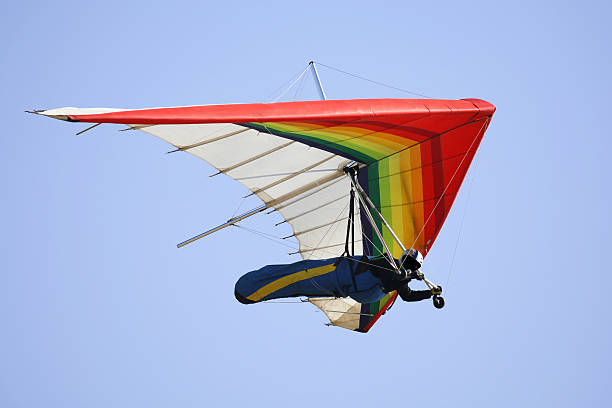 Man hang gliding with blue sky at the background.