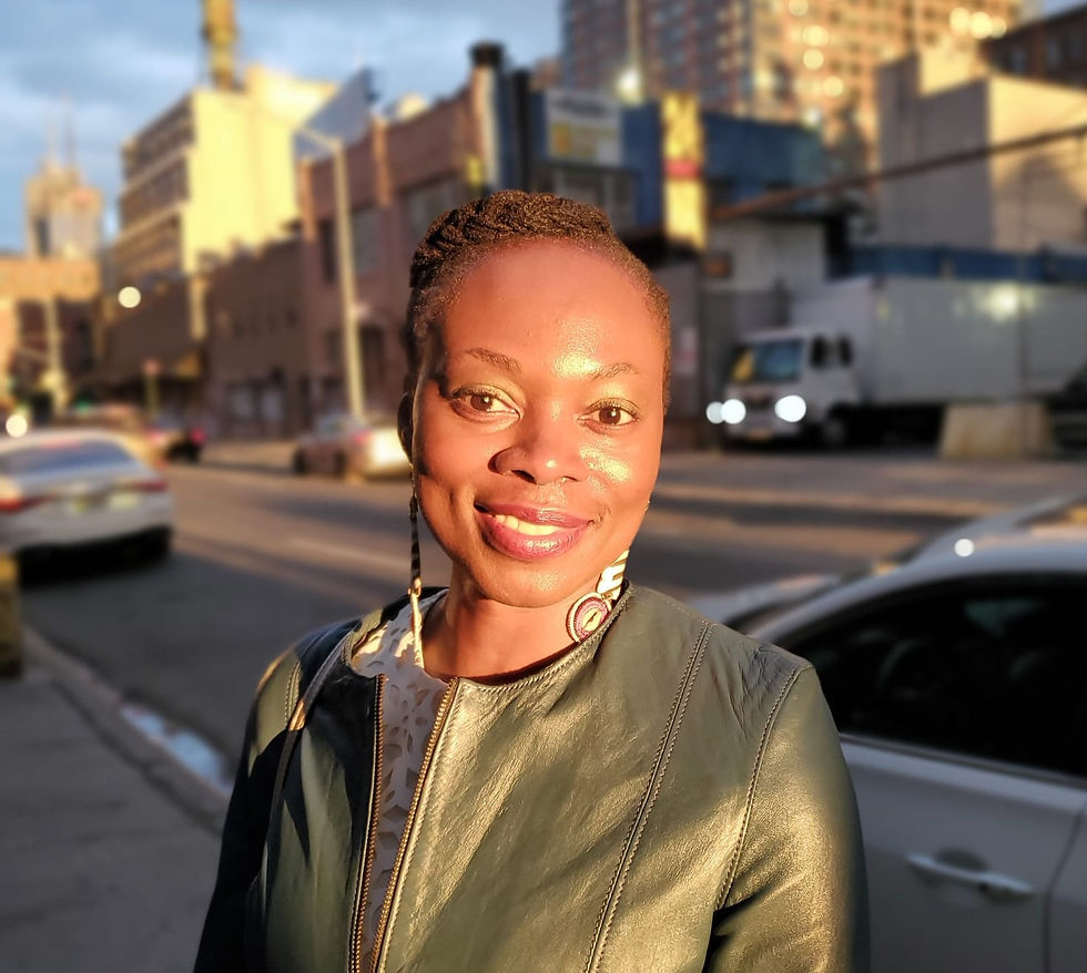 Shot of a woman smiling at camera in the city on a sunny afternoon.