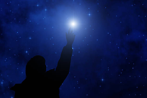 silhouette of a man pointing at the star
