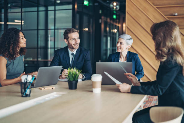 Group of business persons sitting around a table and talking. 