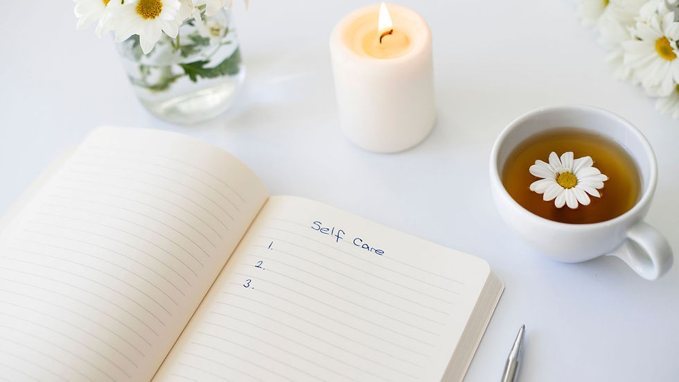 notebook, tea and a candle on a white table.