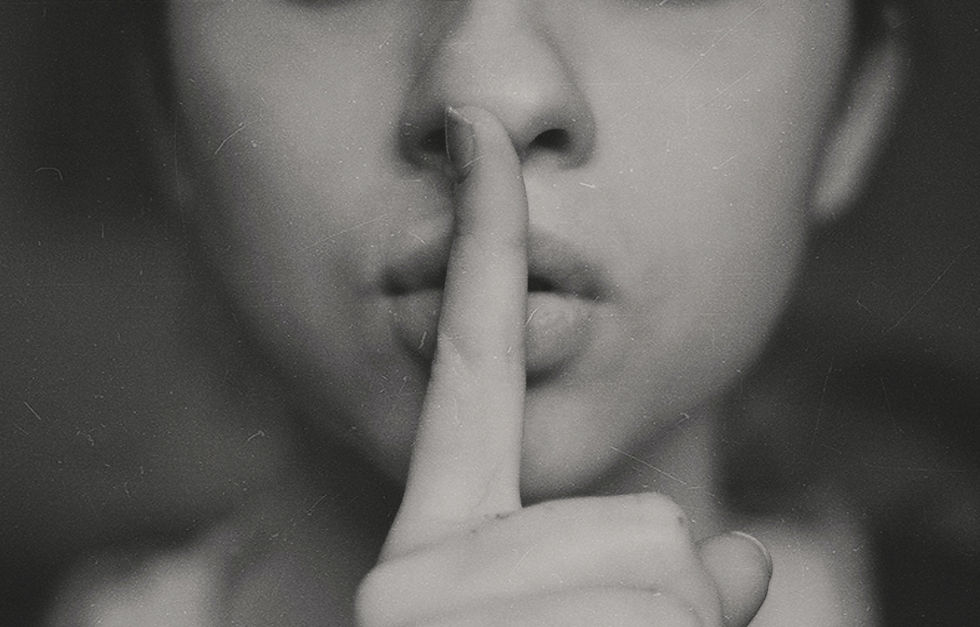 A photo of woman where in her point finger on her mouth.
