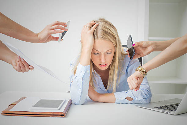 Woman overloaded with stuff at work feeling exhausted.