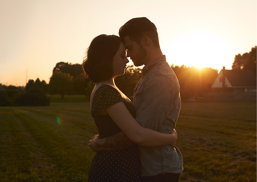 young couple hug each other standing on a beautiful sunset