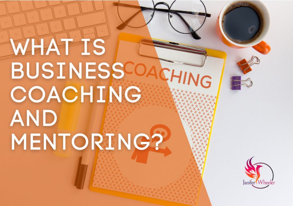 What is business coaching phrase and a laptop, clipboard on a table.