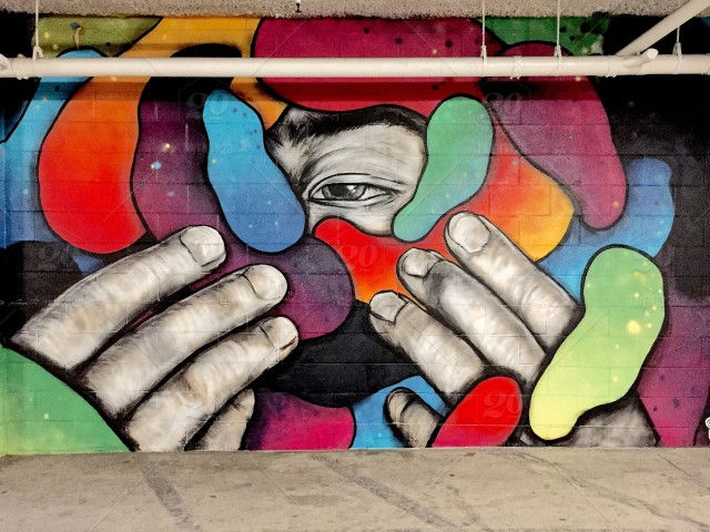 graffiti on wall of a man revealing his face