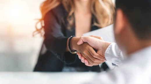 Businesswoman handshake male applicant at the office.