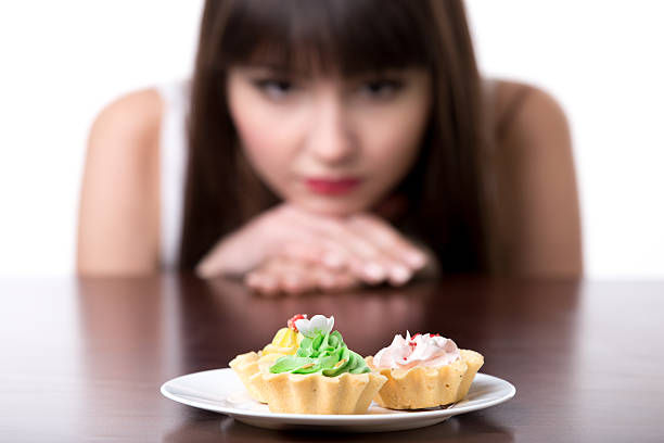 woman sitting in front of plate with delicious cream tart cakes.