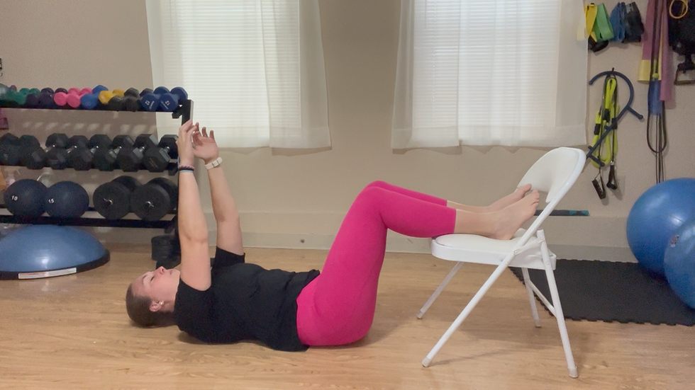 Woman in a room lying on a floor doing exercise. 