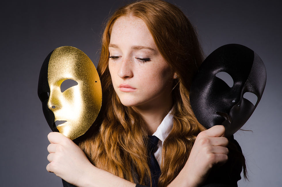 Sad woman holding black & gold mask.