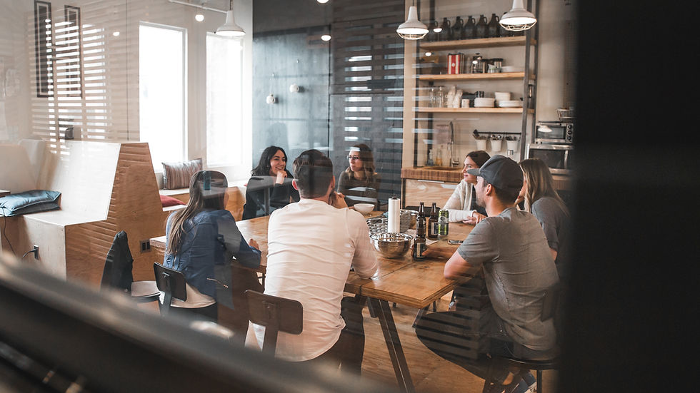group of people gather on the table drinking beer inside the house.
