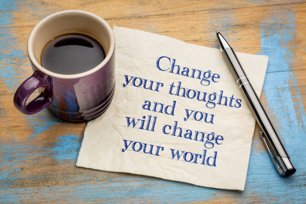 Change your thoughts and you will change your world - handwriting on a napkin with a cup of coffee.