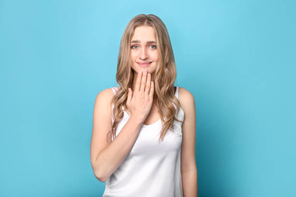 Beautiful woman showing the "thank you" using sign language on blue background. 