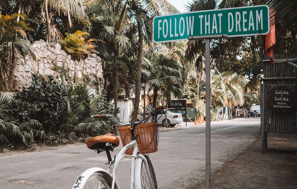 parked white bicycle next to a road sign
