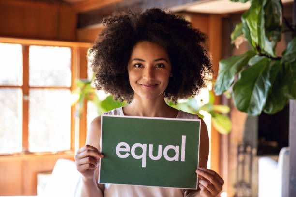 Young woman holding sign stands for equal rights.