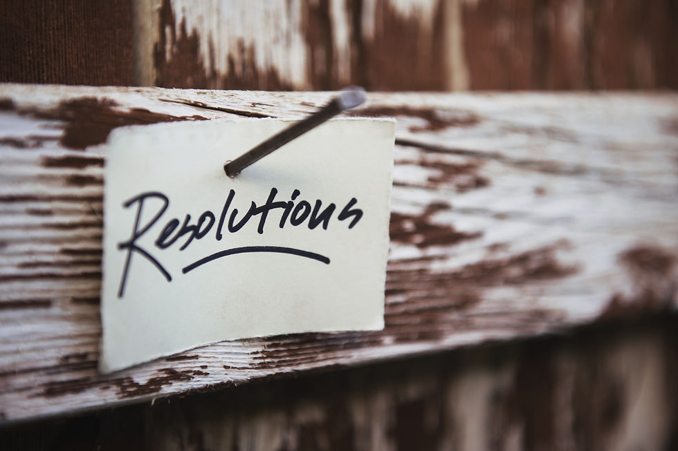 piece of paper with text Resolutions hanging on wooden fence.