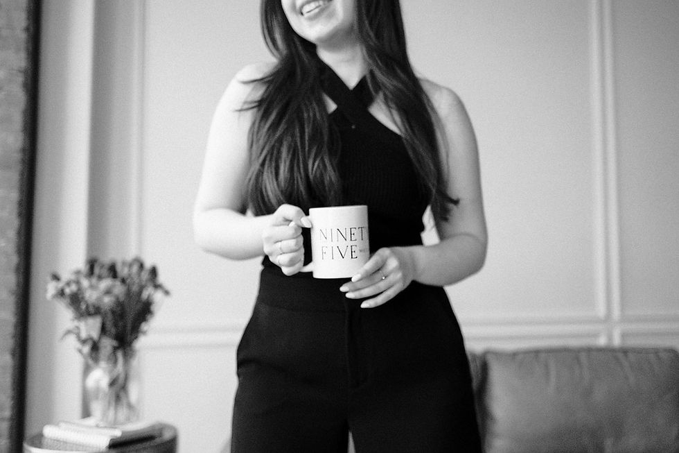 black & white photo of a woman holding a mug.