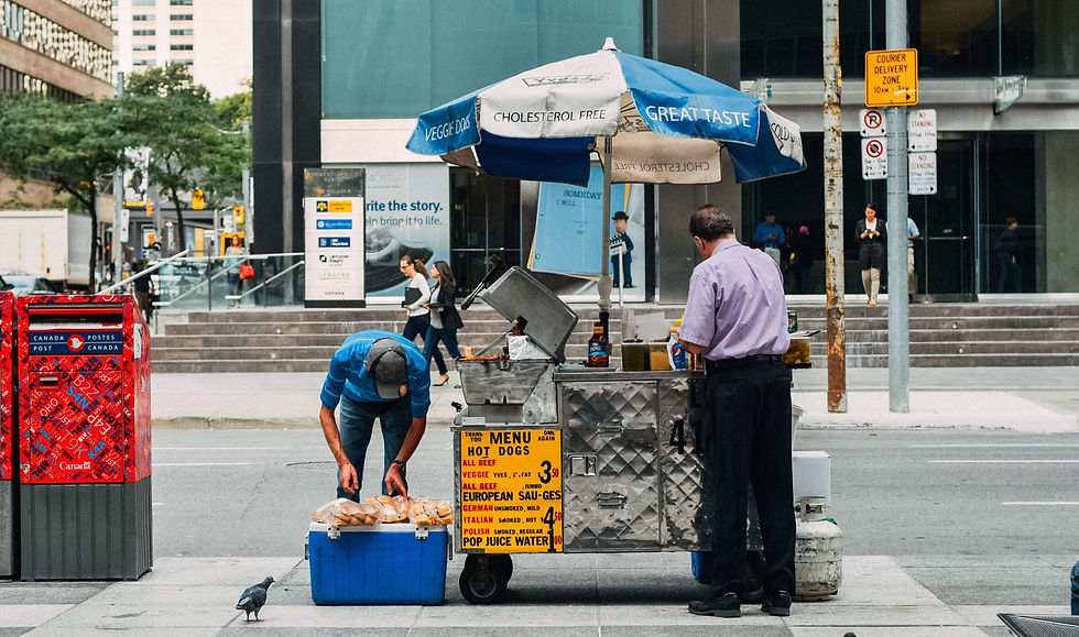 Man selling hotdogs on the street.