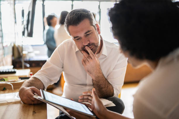 man looking at a digital tablet that a colleague is showing at work