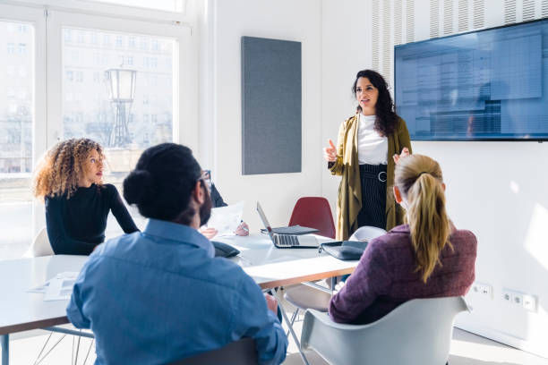 Businesswoman addressing colleagues at a corporate business meeting. 