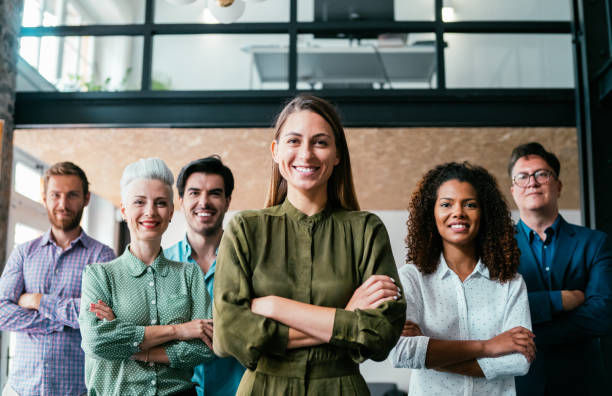 Shot of beautiful confident smiling businesswoman standing in front of her successful team.