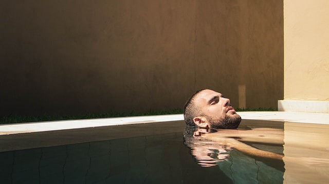 man laying in a pool relaxing