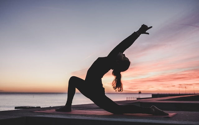 girl doing yoga on the roof at sunrise