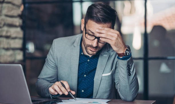 A photo of worried businessman working in the office.