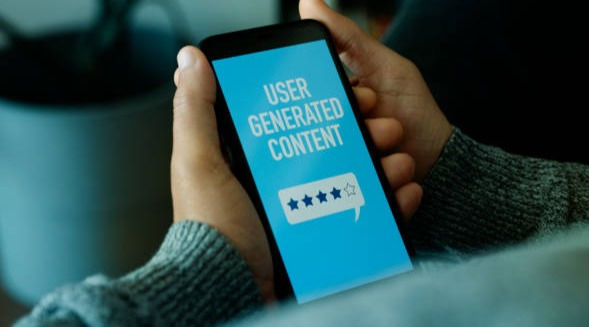 Man and cellphone with text user generated content.